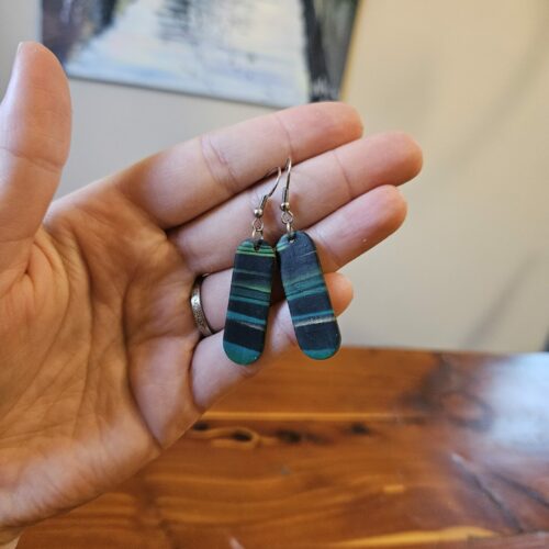 Oblong earrings with black, gold, green, and blue stripes