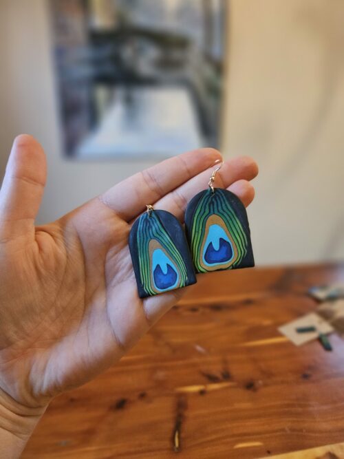 Arch shaped earrings with peacock feather pattern