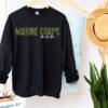 Gildan SF000 crewneck sweatshirt in black with “Marine Corps Mom” written on it with half-camouflage inspired letters