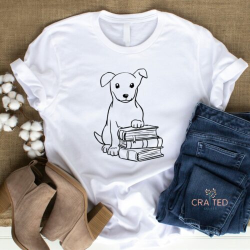 Bella and Canvas Unisex Tee featuring a paws and print doodle outline of puppy sitting on top of a book stack.
