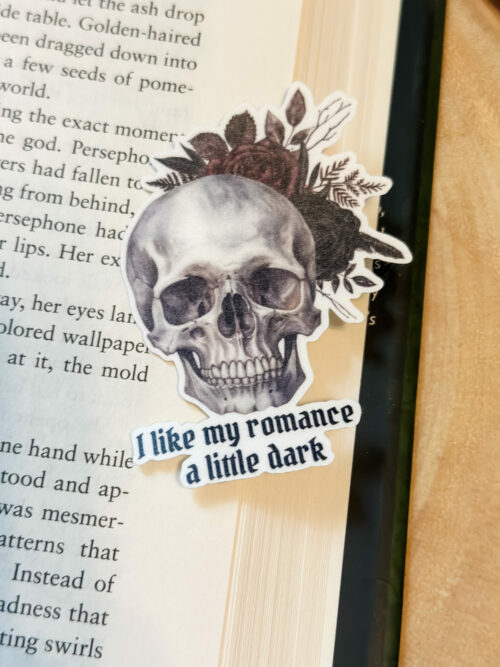 Skull with deep burgundy and black flowers sticker with the saying, “I like my romance a little dark”