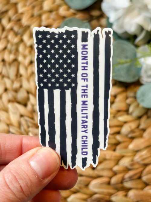 Black distressed flag sticker with purple writing saying, “Month of the military child”